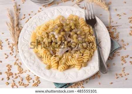 fusilli pasta with peas and onion sauce on table