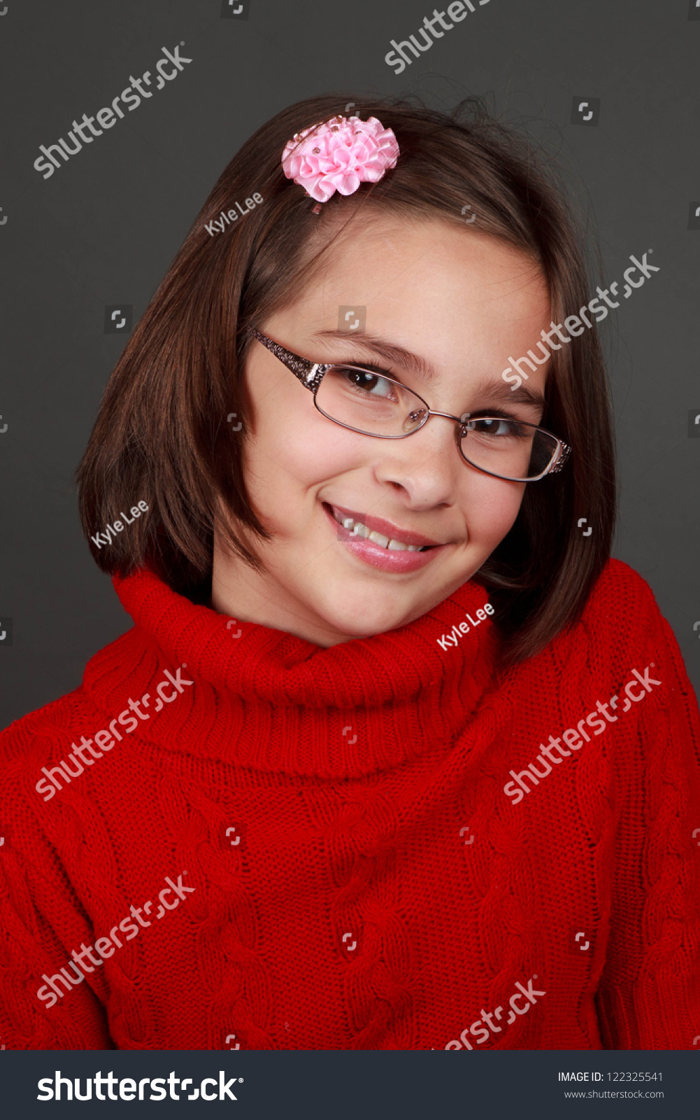 十岁的深色头发的女孩在红色的毛衣戴眼镜