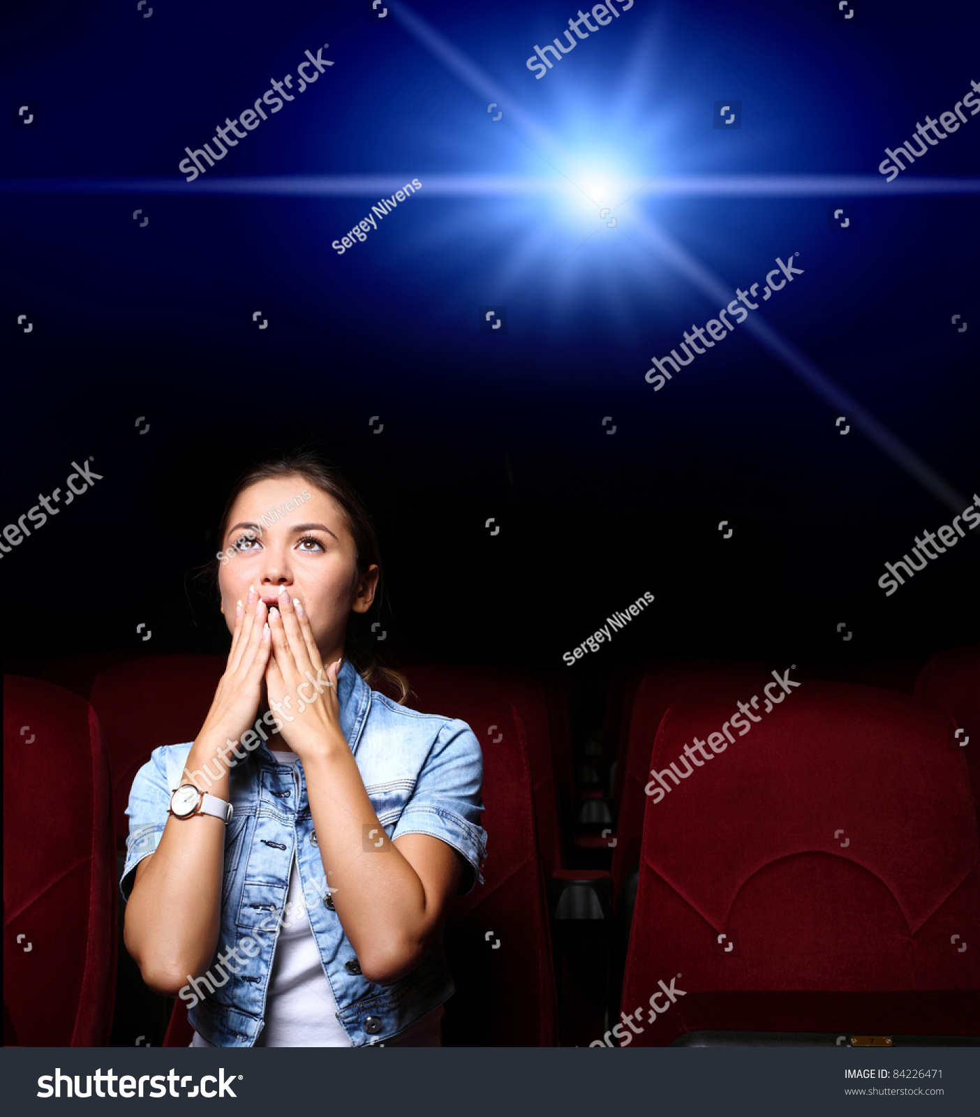 一个年轻的女孩在电影院看电影